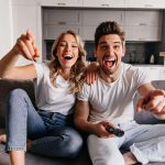 laughing-young-people-sitting-on-couch-smiling-family-watching-tv-min-150x150.jpg