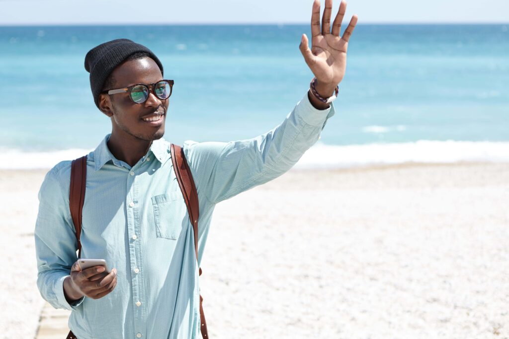 Tourist saying hello in Portuguese at a beach