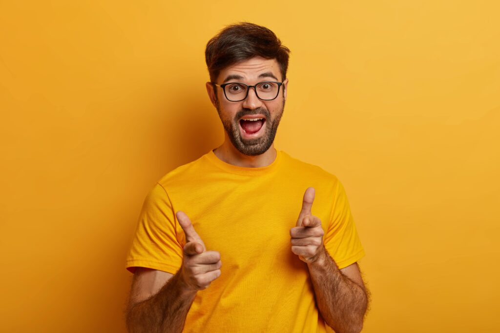 Man in yellow laughing at French jokes