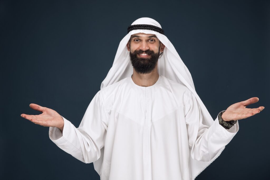 Smiling man in Arab clothing using quotes in Arabic