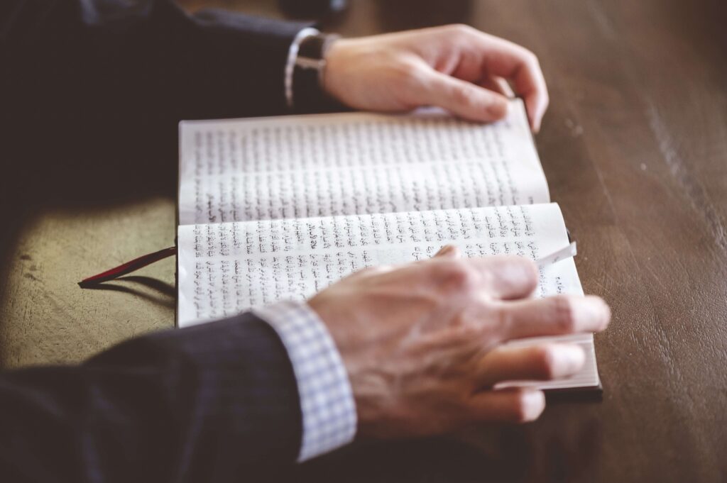 Man reading a book with Arabic quotes