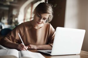 Woman writing on her notebook using correct English punctuation