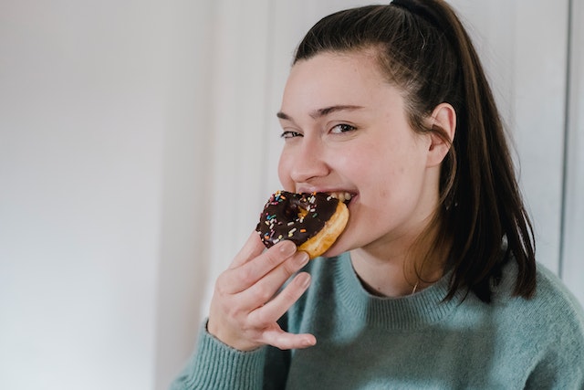 A picture of a girl eating a doughnut