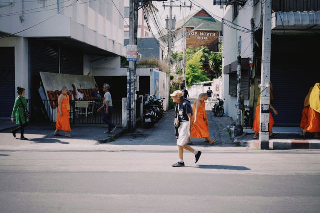 Pedestrians walking along a street in Thailand.