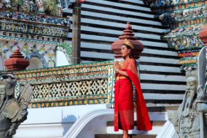 Woman wearing traditional Thai clothing at a decorated temple
