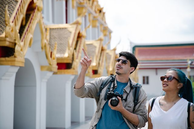 Tourist exploring a Thai temple with a local guide.