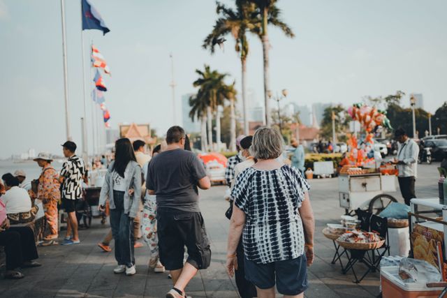 Tourists walking through a busy street market in Thailand